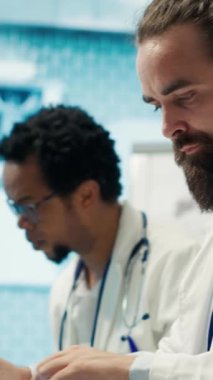 Dikey Video Doktoru, kabine masasına hastalıkların önlenmesi için ilaç öneren bir reçete yazıyor. Klinikteki tıbbi danışmanlık analizleri ve hastane kayıtları.