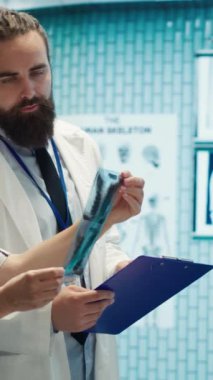 Dikey video doktorları ve radyologlar tedavi hizmetini geliştirmek için insan anatomisi taramalarını inceliyorlar. Doğru sağlık çözümleri için radyoloji ve teşhis konularında ekip çalışması ve uzmanlık yapıyorum. Kamera A.