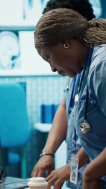 Uzmanlardan oluşan dikey video ekibi, özel bir klinikte yapılan bir toplantıda, hastalıkların önlenmesi için kardiyovasküler sistem analizi ile sonuçlanır. Taramalar ve kayıtlar için danışmanlık. Kamera.