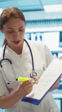 Tıbbi uzmanlardan oluşan dikey video ekibi, bir hastalık için tedavi sağlamadan önce sağlık kayıtları üzerinde x ışını test sonuçlarını vurguluyor. Doktorlar hızla iyileşmesini sağlıyorlar.