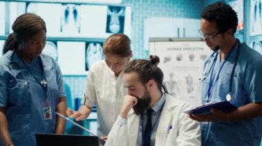 Sağlık uzmanları tedavi planları, takım çalışması ve radyoloji uzmanlığı geliştirmek için insan anatomisi taramalarını inceliyor. Tıp uzmanları özel klinikte analitik üzerinde çalışıyorlar. Kamera A.