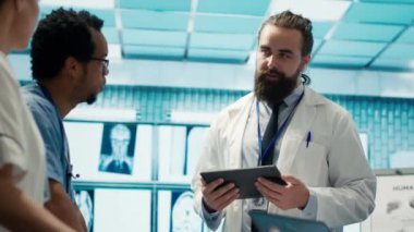 Nöroloji uzmanı, bir toplantı sırasında beyin taraması yapan manyetik rezonans uzmanını inceleyerek, doğru nörobilim teşhisi için tomografiye bakıyor. Çeşitli doktor takımları. Kamera A.