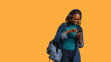 Gülümseyen kadın internet sitesine ödeme metodu ekliyor, satış döneminden zevk alıyor, stüdyo geçmişi var. İnternet alışverişi yapan, akıllı telefondan kredi kartı bilgilerini yazan, müzik dinleyen, kamera B