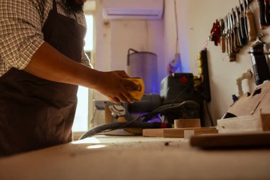 Stüdyoda, tahta yüzeyin pürüzsüz hale getirilmesi için zımpara kağıdı kullanılıyor, ahşap sanat tasarımları yaratılıyor. Ahşap işçiliği, kereste bloğundan zarar gören hasarları onarmak için zımparalama kağıtları kullanıyor.