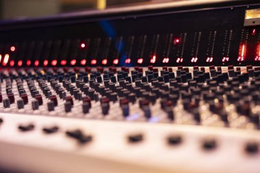 Konsol ve müzik prodüksiyon düğmelerini boş kontrol odasında karıştırmak, yeni parçalar kaydetmek ve üretmek için kullanılan teknik teçhizat. Ses dosyalarını düzenleyen anahtarlar, kaydırıcılar ve düğmeler. Kapat..