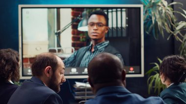 Ekip, yıllık veri raporları ve performans ölçümlerini çevrimiçi video konferansı yoluyla ele alan bir proje brifingini sunmak üzere iş idarecisi ile toplantıya katılacak. Kamera A.