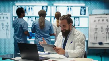 Neşeli, kendine güvenen doktorlar ve hemşireler teşhis için doğru tedavi planını buluyorlar. Yetenekli sağlık sektörü çalışanları. Sağlık personeli gülümseyip el çırpıyor. Dolapta iyi haberler var. Kamera B.