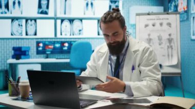 Sinirli doktor, tehlikeli hastalıklara karşı en iyi tedaviyi bulmak için baskı altında çalışan dosyaları atıyor. Doktor, özel bir klinikte test sonuçlarını incelerken kendini öfkeli hissediyor. Kamera B.