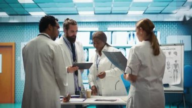 Profesyonel doktorlar iyi bir sağlık sigortası hizmeti için özel klinikteki hastane kayıtlarını ve tedavi planlarını gözden geçirirler. Çeşitli uzmanlar çözümler için test sonuçlarını analiz ediyorlar. Kamera B.