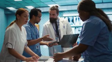 Uzman doktor, departman toplantısında tedavi planı bulmak için test sonuçlarını personelle birlikte analiz eder. Lisanslı doktorlardan oluşan bir ekip radyoloji teşhisi ve genel uzmanlık sağlamak için birlikte çalışıyor. Kamera B.