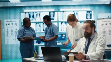 Sağlık uzmanları tedavi planları, takım çalışması ve radyoloji uzmanlığı geliştirmek için insan anatomisi taramalarını inceliyor. Tıp uzmanları özel tesiste analitik üzerinde çalışıyorlar. Kamera B.