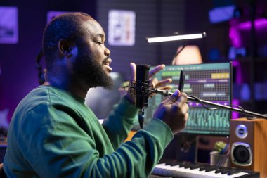 Ünlü müzisyen şarkısının akustik versiyonunu seslendiriyor, cep telefonundan mısraları okuyor. Yetenekli söz yazarı yeni bir şarkı besteleyip mikrofondan ses kaydediyor..