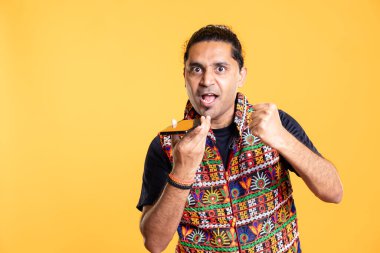 Telefon görüşmesi sırasında arkadaşlarıyla kavga eden rahatsız Hintli bir adamın portresi stüdyo arka planında izole edilmiş. Cep telefonuyla konuşurken arkadaşlarıyla tartışan öfkeli bir insan.