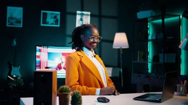 Üniversite öğrencisinin portresi, okul işleri için dizüstü bilgisayar kullanarak evinde oturuyor. Genç bir kadın profesyonel platformlar aracılığıyla kariyer yollarını ve ağ kurma fırsatlarını keşfediyor. Kamera B.