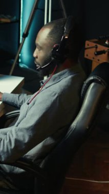 Dikey Video Adam, SF FPS video oyunu oynamak için kulaklık kullanıyor, karanlık apartman dairesinde eğleniyor. Oyuncu PVP online multiplayer oyununda yarışıyor, diğer oyuncuları fütüristik silahla vuruyor, kamera B kapanıyor