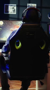 Evdeki dikey video oynatıcı uzay gemisi uçan tekil oyuncu oyununda asteroidleri vuruyor ve HUD ekranda sağlık seviyelerini gösteriyor. Simülasyon oyununda evreni yöneten kişiyi kapat