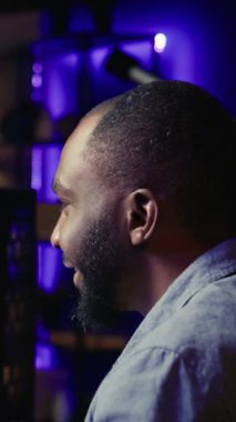 Dikey Video Adam takım arkadaşlarıyla sohbet ederken bilgisayar oyunu oynarken eğleniyor. Heyecanlı oyuncu rakip oyuncularla savaşıyor, mikrofon ve kamera B aracılığıyla arkadaşlarıyla iletişim kuruyor.