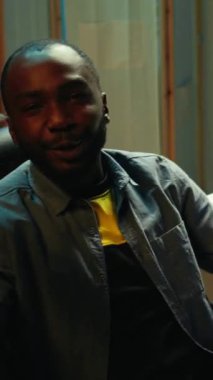 Dikey video Afrikalı Amerikalı adam abonelere profesyonel esport becerileri ve nasıl oyun oynanacağını öğretiyor. Medya yıldızı oyun sandalyesinde izleyicilerle sohbet ediyor, oyun dersi, kamera B