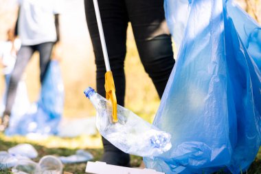Kadın çevreci, orman çevresindeki kirlilikle, ekolojik adaletle savaşmak için yerden çöp topluyor. Ormanı çöpten temizlemek için gönüllü kamu hizmeti yapıyor..