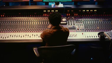 Afrikalı Amerikalı müzik yapımcısı yeni şarkısını prodüksiyon sonrası bir şarkı kaydederek ve düzenleyerek profesyonel stüdyoda bitiriyor. Yetenekli ses mühendisi karıştırma ve ustalaşma melodileri. Kamera B.