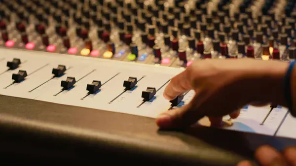 stock image Artist composer creating a new song on his electro guitar in studio, recording tracks in control room using mixing console and amplifier. Songwriter creates new music for his album. Camera A.