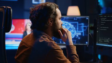 Bilgisayar bilimcisi yapay zeka sinirsel ağlarını görselleştirmek için bilgisayara kod yazar. Uzaktan bilişim işçisi kişisel ofis, kamera A 'dan bilgi işleme için yapay zeka betiği çalıştırır