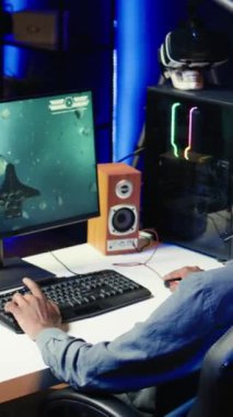 SF video oyunu oynarken arkadaşlarıyla tartışmak için kulaklık kullanan dikey video oyunu, kapatın. Arkadaşlarla fütürist kümesteki uzay gemisi atari oyununun tadını çıkarırken sohbet ediyoruz.