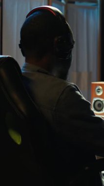 Dikey Afrikalı Amerikalı adam kulaklık takıyor bilgisayar ekranında SF uzay video oyunu oynuyor bulanık arka planda, lazer ateşliyor. Bilgisayar ekranında galaksi uçuşundan hoşlanan kişiye yakın çekim