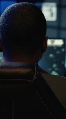 Neon ışıklı yatak odasındaki bilgisayar ekranında SF video oyunu oynayan dikey video adam. Oyuncu, RGB 'de bilgisayar ekranında uzay gemisi uçurma oyununun keyfini çıkarırken, gece geç saatlerde evi aydınlattı, kamera B de çekim yaptı.