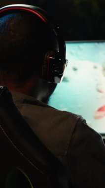 Dikey Video Adam, PC ekranında, kulaklık takarak, asteroit vurarak bilgisayar oyunu oynuyor. Oyuncu bilgisayar ekranında uzay gemisinin uçuş oyunundan zevk alıyor, meteorları ve kameraları yok ediyor