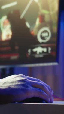 Dikey video oyunu bilgisayar çevresi kullanarak PC monitöründe FPS siber uzay video oyunları oynuyor. Bir adamın klavye ve fare kullanırken, masada online oyun oynarken, eğlenirken yakın plan çekimleri.
