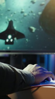 Evde dikey video adam, PC 'de bilim kurgu video oyunu oynamak için bulut oyun servisini kullanıyor. Oyuncu yüksek kaliteli oyunu seviyor, çevrimiçi yayınlıyor, uçan uzay gemisi, kamera B