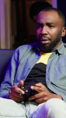 Konsol sisteminde kumanda kullanarak bilgisayar oyunu oynarken kaybettikten sonra dikey video oyunu üzülüyor. Adam mağlup olduktan sonra hayal kırıklığına uğruyor. Oyun sahası, kamera A ile oyun oynuyor.