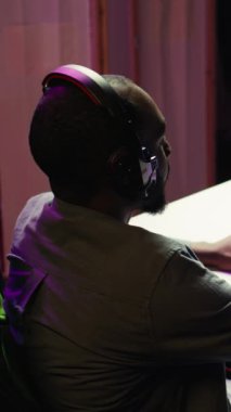 Dikey video oyunu oyuncusu kulaklık takıyor, oyun oynuyor, izleyicilere gerekli becerileri öğretiyor. Oyun koltuğunun yaratıcısı, izleyicilerle konuşuyor, düşmanları nasıl yeneceğini anlatan bir film çekiyor.