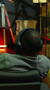 Dikey Videocu, büyük akıllı televizyonlarda uzay gemisi uçan video oyunu oynuyor, kulaklık takıyor. Oyuncu oyun konsolunda SF atari oyunundan zevk alıyor, Galakside oyun sahası kullanarak uzay aracına pilotluk yapıyor