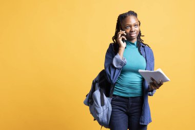 Neşeli bir genç iş arkadaşıyla telefon görüşmesi yapıyor, okul ödevlerinden, stüdyo geçmişinden bahsediyor. Göz kamaştırıcı öğrenci telefon görüşmesinde eğleniyor, elinde notlar tutuyor.