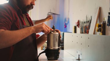 Mobilya montajında çalışan tamirci, çim biçme makinesinin pervanesini değiştiriyor. Ahşap işçiliği stüdyosundaki mühendis arızalı ahşap şekillendiriciyi tamir ediyor, hasarlı parçayı değiştiriyor, kamera B