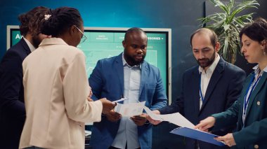 Çeşitli işletmeler, arşivlenmiş belgelerdeki maliyeyi inceleyerek, bütçe ve mali tahminleri inceleyerek pazar eğilimlerini araştırmaktadır. İş arkadaşları bilgi paylaşım toplantısına katılıyor. Kamera A.