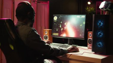 Arkadaşlarıyla internetteki çoklu oyunculu uzay gemisi video oyununun keyfini çıkarmak için kulaklık kullanan adam, kapat. Takım arkadaşlarıyla iletişim kuran oyuncu mikrofon, uçan uzay aracı, kamera B