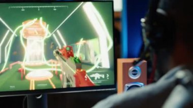 SF FPS video oyunu oynamak için kulaklık kullanan bir adam, karanlık bir dairede eğleniyor. Oyuncu PVP online multiplayer oyununda yarışıyor, diğer oyuncuları fütüristik silahla çekiyor, kamera A yakın plan