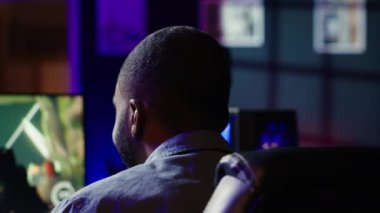 Adam takım arkadaşlarıyla sohbet ederken bilgisayar oyunu oynarken eğleniyor. Heyecanlı oyuncu rakip oyuncularla savaşıyor, mikrofon ve kamera A aracılığıyla arkadaşlarıyla iletişim kuruyor.