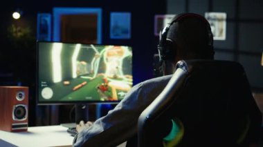 Oyuncular online çok oyunculu bilim kurgu video oyunu turnuvasını kazanmayı kutluyorlar, havaya yumruk sallıyorlar. Adam bilgisayardaki B kamerasındaki şampiyonluk maçından memnun.