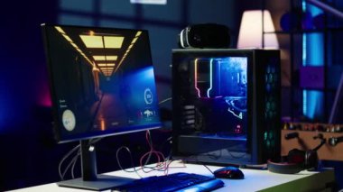 FPS video oyunu boş neon ışıklı apartman odasındaki bilgisayar ekranında açık kaldı. RGB 'de bilgisayar masaüstü ekranında atış oyunu gece geç saatlerde evde kimse yokken yakıldı