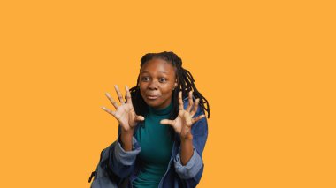 Neşeli Afrikalı Amerikalı ergen aylaklık ediyor, neşeli hissediyor, stüdyo arka planında izole edilmiş. Mutlu genç kızın portresi aptalca davranıyor, pozitif tavır sergiliyor, kamera A