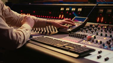 Ses teknisyeni kontrol odasında karıştırma konsolu ve faders kullanır, karıştırıcıdaki sesi ayarlamak için uzaktan kumanda. Müzik yapımcısı ses seviyesini değiştiriyor, teknik ekipmanlarla izler yaratıyor. Kamera B.
