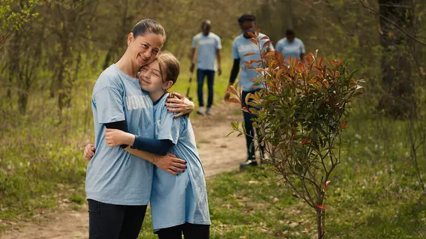 stock image Portrait of mom and child protecting the environment by collecting rubbish, activism. People cultivating consciousness by eliminating plastic pollution and trash from the woods. Camera A.