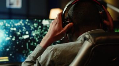 Bilgisayar ekranında SF uzay oyunu oynayan, asteroit çeken, kulaklık takan bir adam. Oyuncuların bilgisayar masaüstü ekranında uzay gemisi uçuş oyununun keyfini çıkarırken meteorlarda gezinmelerini kapatın