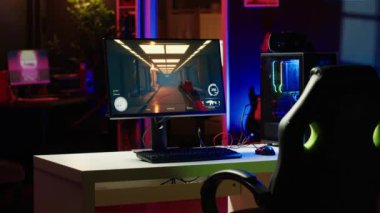 Gece yarısı video oyunu UI arayüzünü gösteren, neon ışıkları ve bilgisayar ekranı açık bırakılmış boş bir daire. Evde kimse yokken oturma odası ve bilgisayar ekranı açık kalmış.