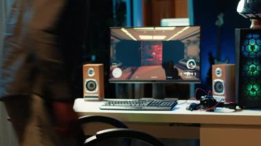 Çok oyunculu online video oyununda yarışmak için kulaklık takan profesyonel bir oyuncu, apartmandan canlı yayın yapıyor. PC 'de flamalar çalıyor, dinleyicilerle konuşmak için kulaklık kullanıyor, kamera A