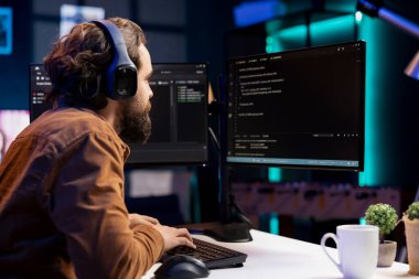 BT programcısı müzik dinlerken yazılımdaki savunmasızlıkları düzeltiyor ve hackerların işletim sistemini tehlikeye atıyor. Siber güvenlik uzmanı kulaklık takıyor ve güvenlik açığını kapatmak için bilgisayar kullanıyor.